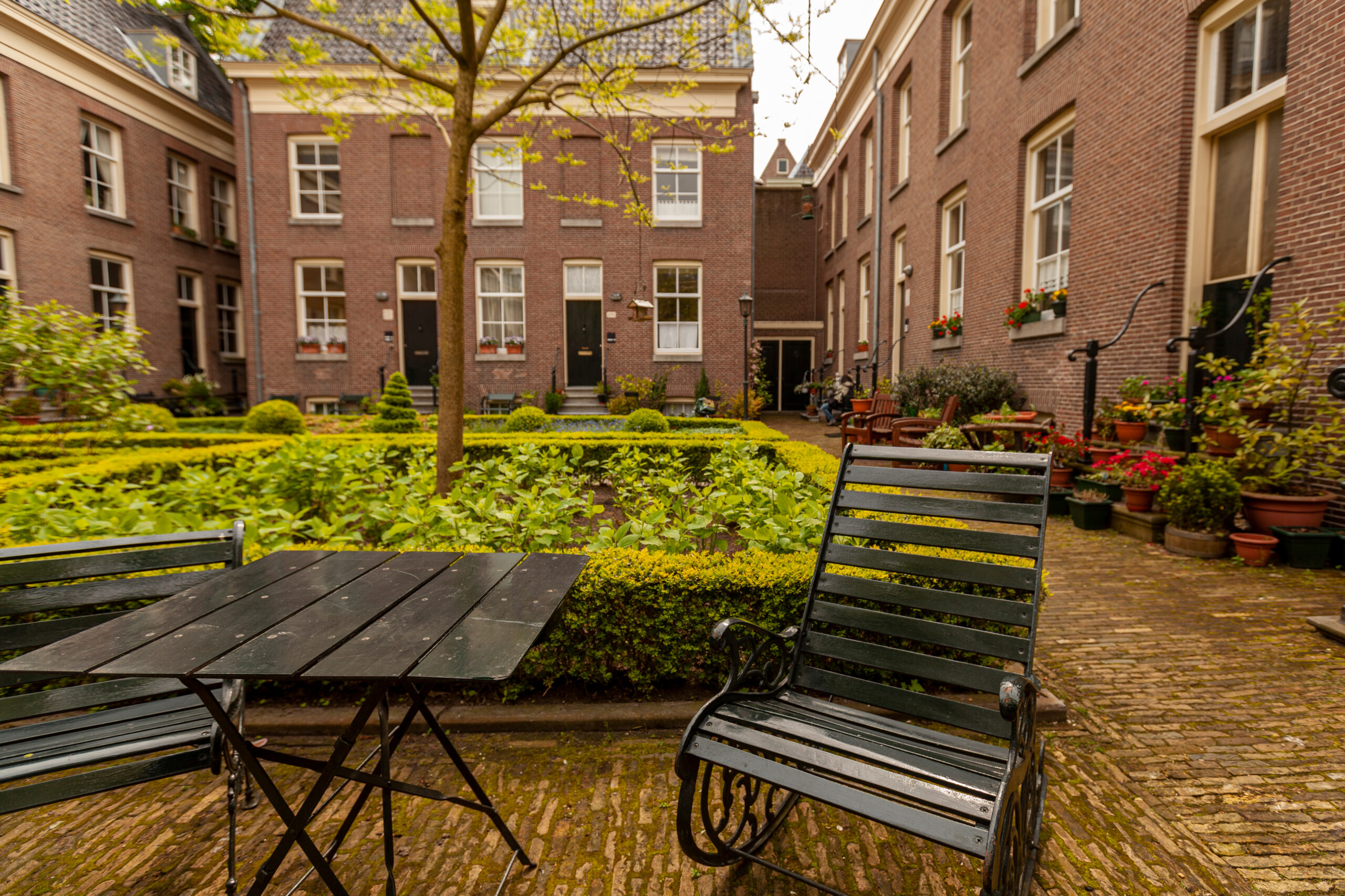Senior living facility courtyard with greenery and furniture.